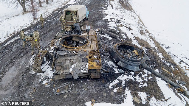 Militares ucranianos inspeccionan un tanque ruso carbonizado que fue destruido en las afueras de Sumy, en el este de Ucrania.